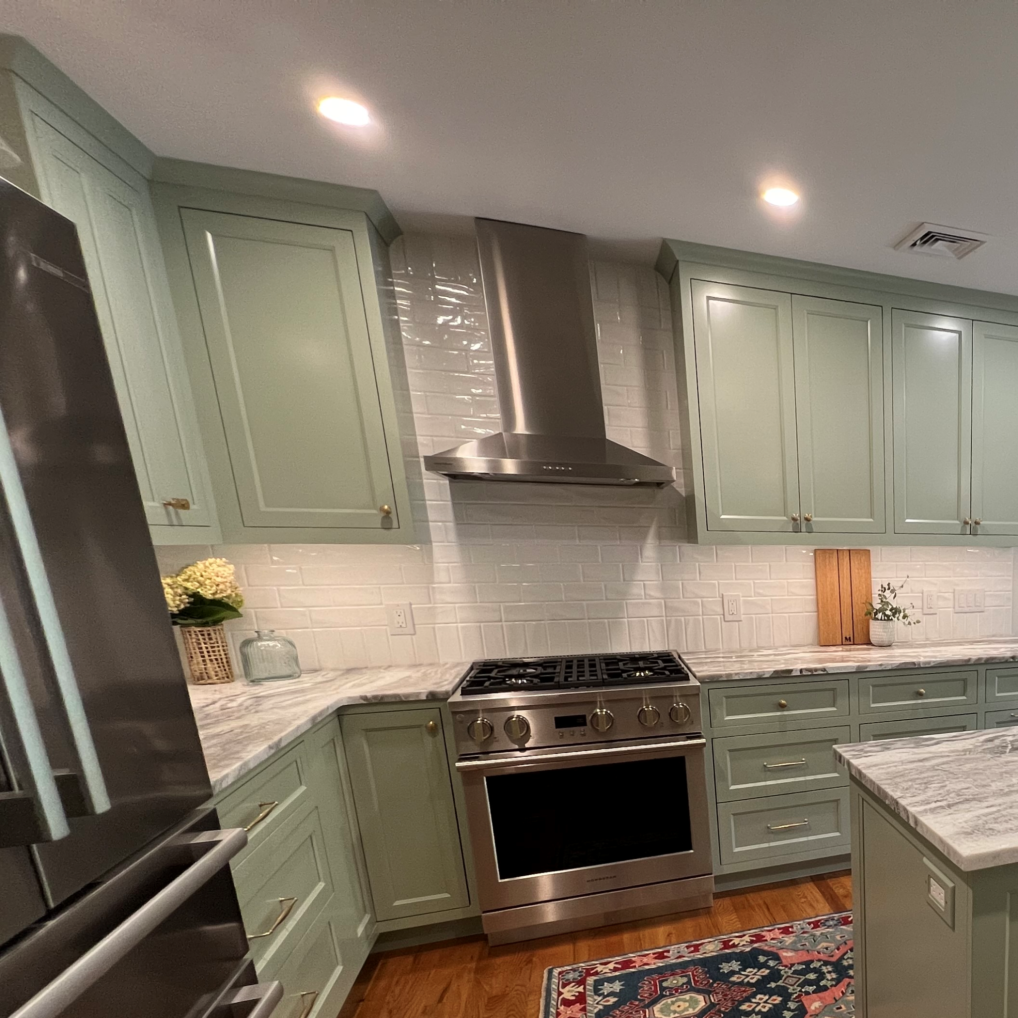 Flush-inset cabinetry and custom hood surround at the range wall