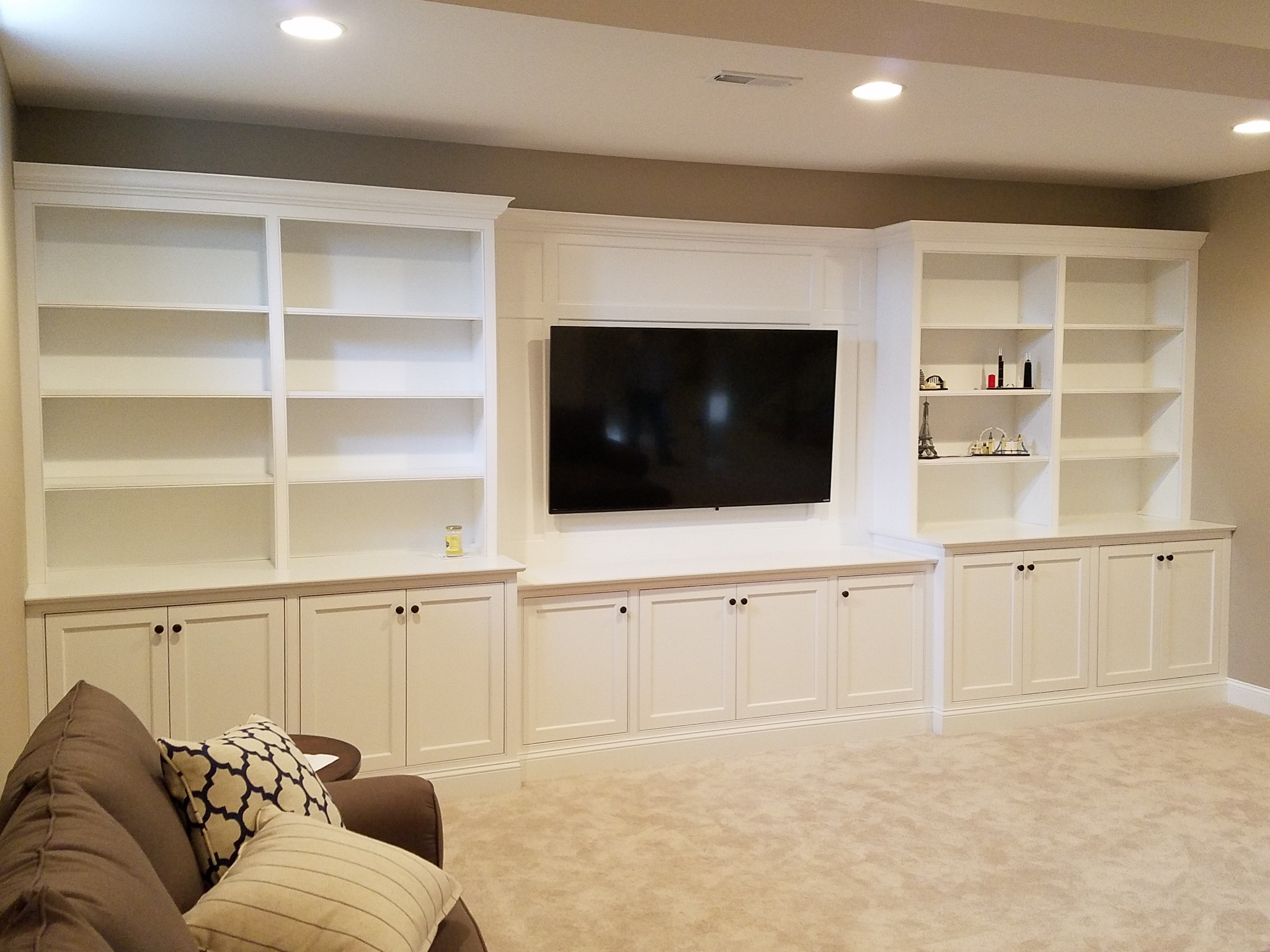 Large white custom built-in entertainment center with shelving and cabinet storage
