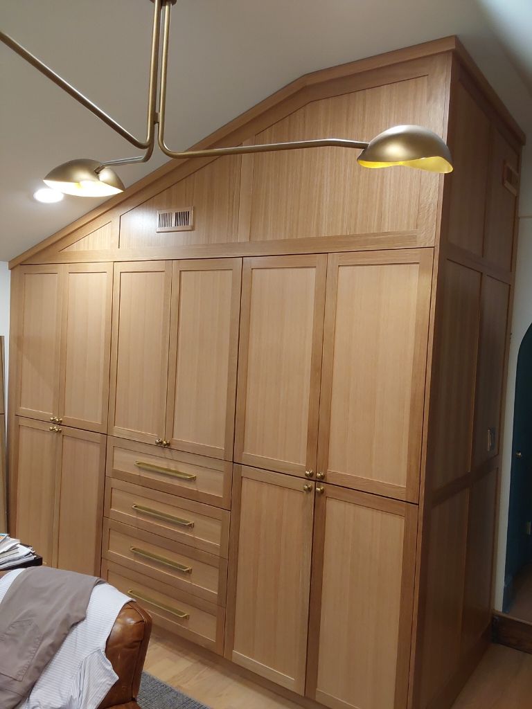 White oak custom closet system with fitted hanging space, drawers and open shelving