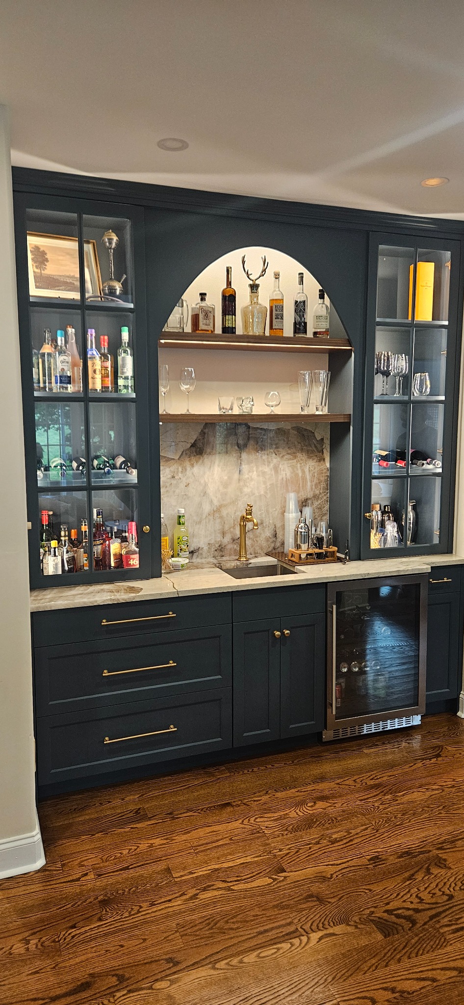 Custom home bar cabinetry with glass uppers