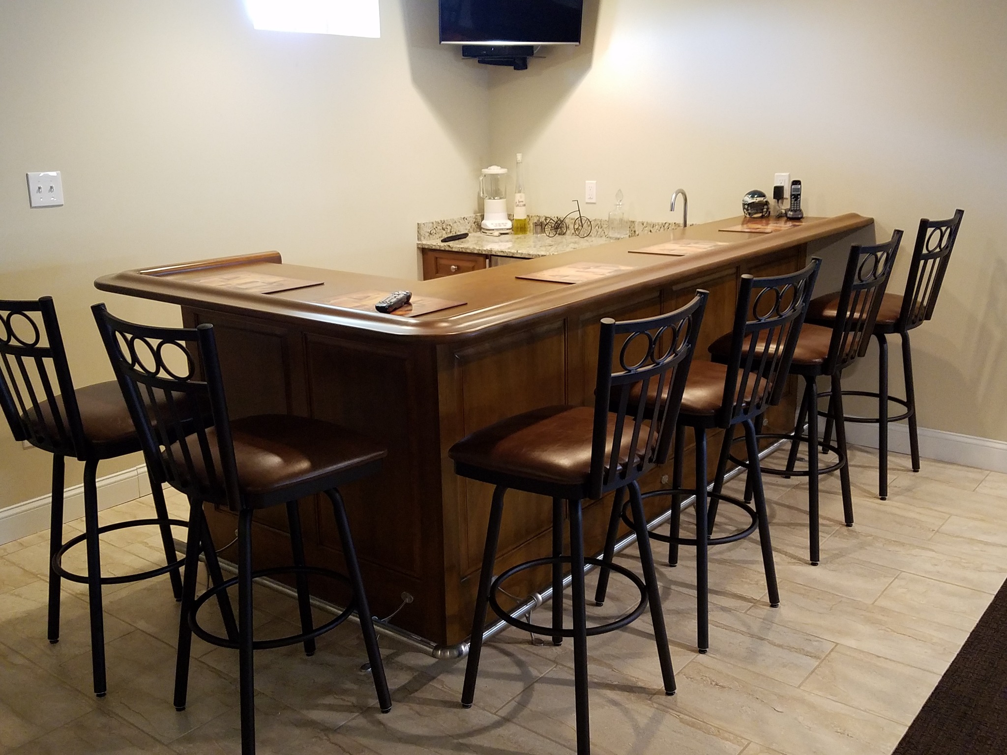 Custom home beverage bar cabinetry with upper display storage and stone countertop